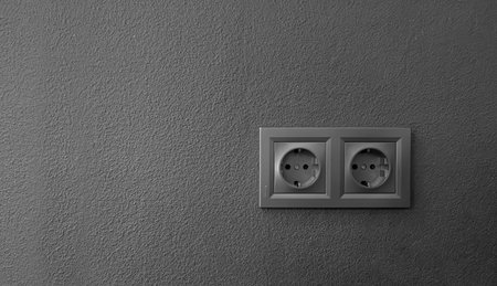 A gray textured wall with outlets enhances modern interior decor. Its subtle texture and outlets...