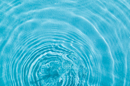 drops on water with circles on a blue background close upの写真素材