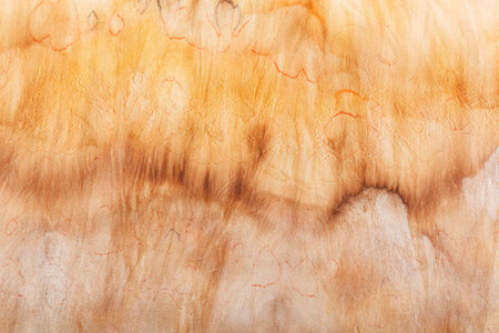 abstract pattern on silk fabric texture in yellow and brown tones close-upの写真素材
