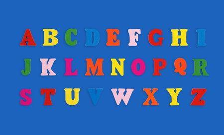 wooden letters of the English alphabet multi-colored on a blue background close-upの写真素材
