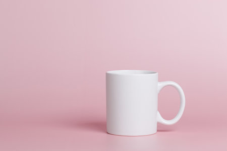 white cup for tea or coffee on a pink background close-upの写真素材