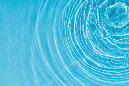 drops on water with circles on a blue background close upの写真素材