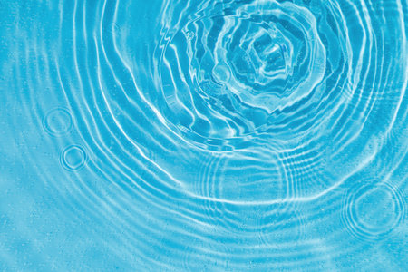 drops on water with circles on a blue background close upの写真素材