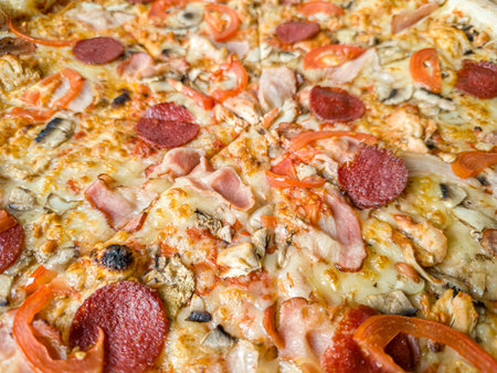 A meat pizza with bacon and salami with melted cheese offers a tempting close-up view. Its rich flavors make it perfect for food-related content.の写真素材