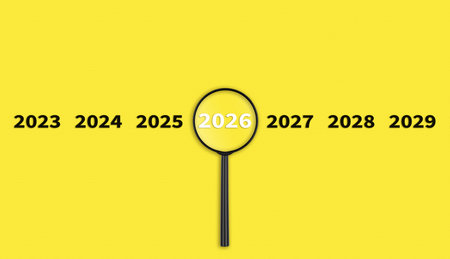 Lens, magnifying glass focusing on the year 2026 on a Yellow background. Financial or stock market...