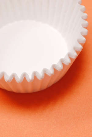 white muffin cups on bright orange backgroundの写真素材