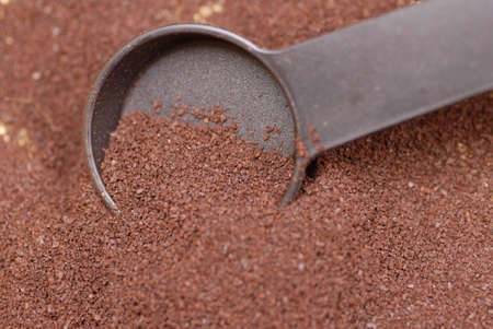 fresh ground coffee beans with measuring scoopの写真素材