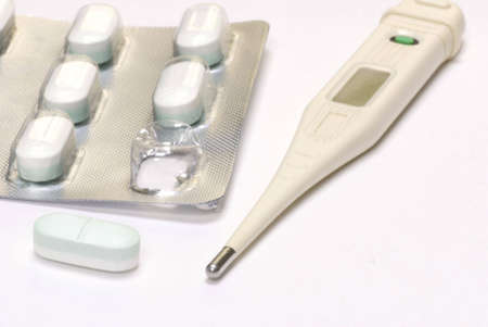thermometer and pill blisterpack ready to get rid of that fever
