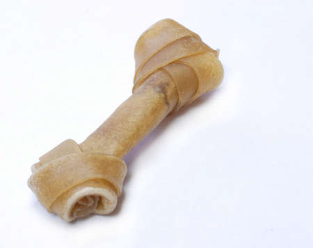 dog treat - twisted rawhide bone on white backgroundの写真素材