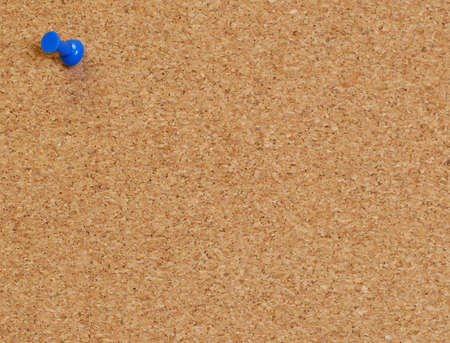 cork board with blue push pin or thumb tack