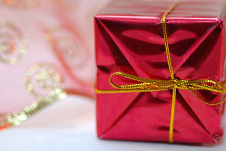 red christmas present with gold bow - on white background