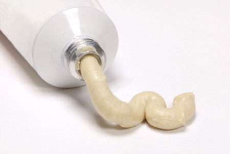 white tube with ointment squeezing out on white backgroundの写真素材