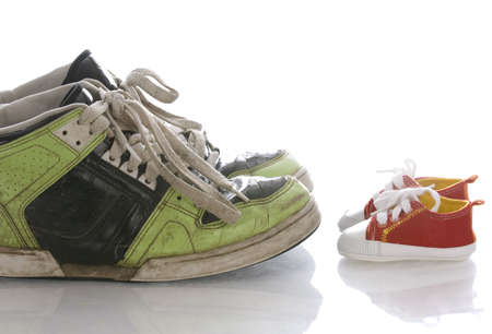 big old shoes and new baby or infant shoesの写真素材