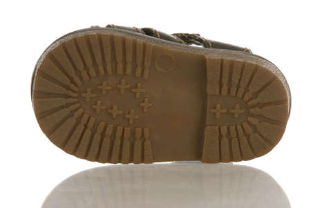sole of baby or infant shoe with reflection on white backgroundの写真素材