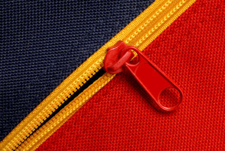 close up of red and blue canvas with yellow zipperの写真素材