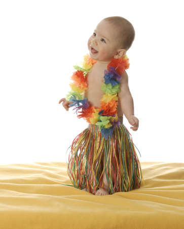 six month old baby dressed up wearing hawaiian skirt and leiの写真素材