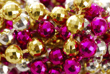 background of colorful mardi gras beads including gold, silver and pinkの写真素材