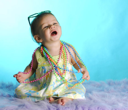 baby girl with two front teeth wearing colorful clothes on blue backgroundの写真素材