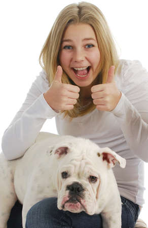teenage girl giving thumbs up with her dog on her lap on white backgroundの写真素材