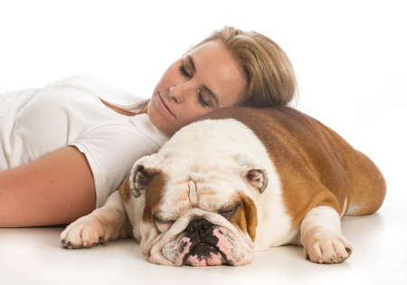 woman laying down with head resting on english bulldogの写真素材