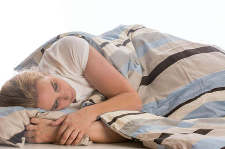 young woman sleeping in bed on white backgroundの写真素材