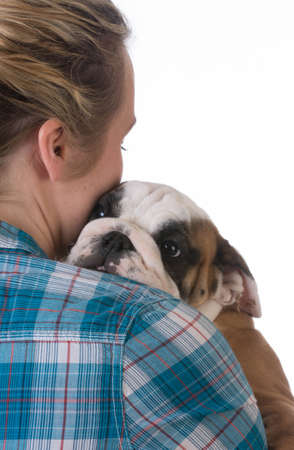 woman hugging new puppy on black background - 8 week old bulldogの写真素材