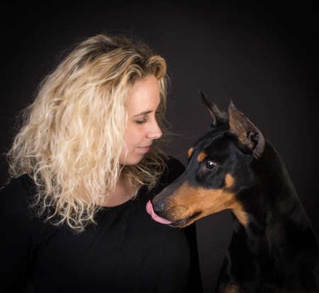 woman and doberman pinscher on black backgroundの写真素材