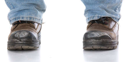 man's legs wearing workboots on white background