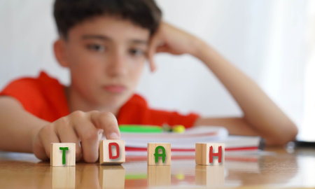 child with attention deficit disorder (Spanish acronyms) frustrated doing homework, importance of educational needs and special attention to this problem.の写真素材