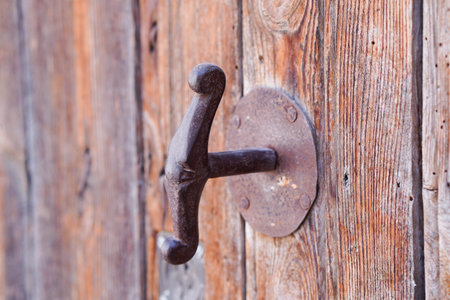 rusty antique iron door handle on wooden doorの写真素材