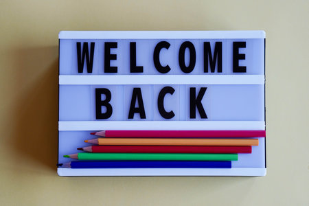 light box with words WELCOME BACK and colored pencilsの写真素材