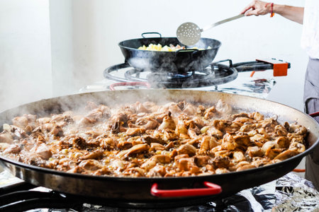cooking chicken and potatoes with gas canister and paellaの写真素材