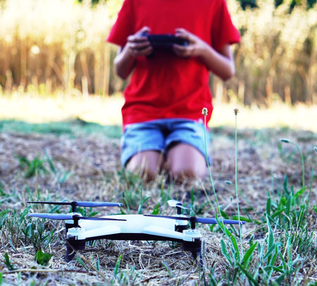 close-up of drone being operated by a child in the field