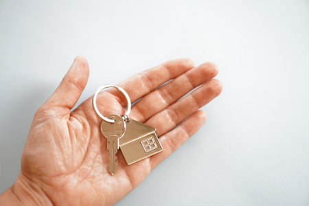 open hand with key and key ring of a house