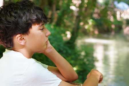 pensive teenage boy observing natureの写真素材