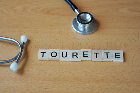 medical concepts. tourette. word written in wooden letters with a stethoscope.の写真素材