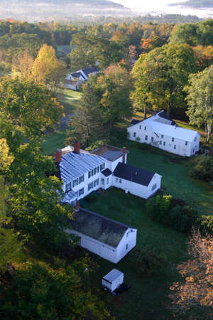 An aerial view of a hot air balloon floating over the Vermont country side 
