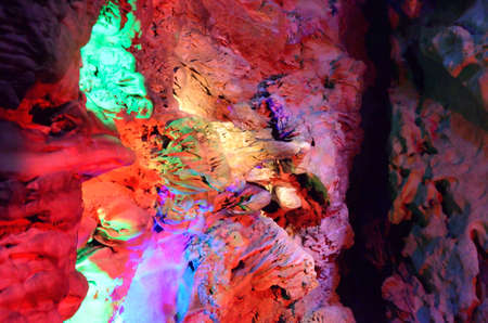 beautiful illuminated multicolored stalactites from karst Reed Flute cave. Guilin Guangxi Chinaの写真素材