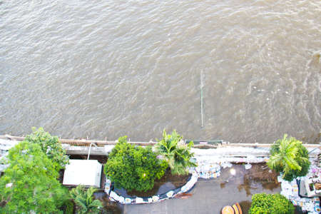 BANGKOK, THAILAND - OCTOBER 25: A group of sandbags are laid in front of pier which sinks in Chao phraya river in  Siriraj hospital for flooding prevention on October 25, 2011 in Bangkok, Thailandのeditorial素材