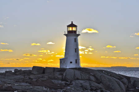 Sun settling behind the lighthouse at Peggy's Cove, NSの写真素材