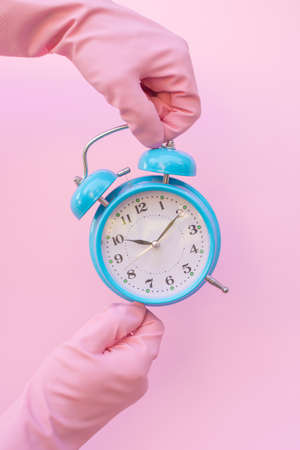 Pink cleaning gloves and clock