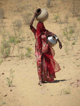 Woman on her way to collect water from the local well in Indiaの写真素材