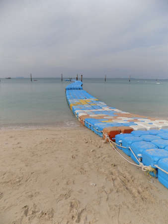 Pontoon made from plastic floats used to access small boats from a beach on Koh Larn Island in Thailand.の写真素材