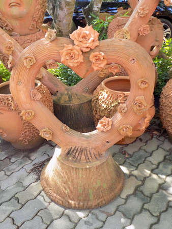 Roses made from terracotta on a terracotta heart shaped log.の写真素材