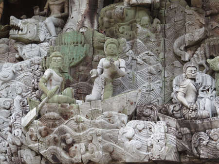 Intricate carving on a large building made entirely from wood in Pattaya, Thailand. The wood on parts of the building is clearly very old and showing signs of decay, whilst other parts are relatively new.の写真素材