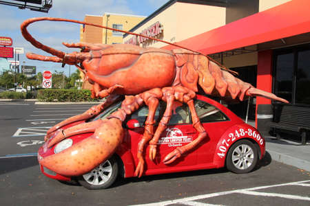 Kissimmee, USA - 13 November, 2019: Giant model lobster mounted on a small car advertising a seafood restaurant in Florida.のeditorial素材