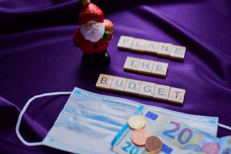 Christmas and New Year 2021. Santa Claus, medical mask and euro money on purple background.の写真素材