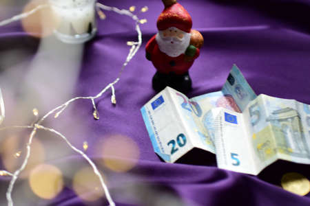 Christmas card with Santa Claus and euro banknotes on a purple backgroundの写真素材