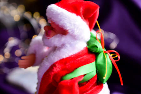 Santa claus doll with christmas decoration on bokeh backgroundの写真素材