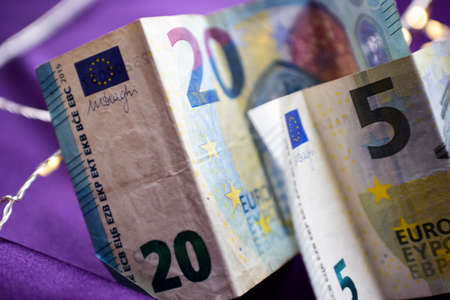 Euro banknotes on a purple background, close-up, selective focusの写真素材